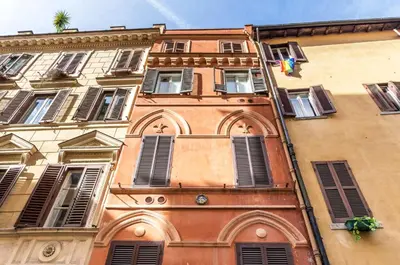 a tall building with windows and shutters on it at Cozy studio Campo de Fiori in Rome