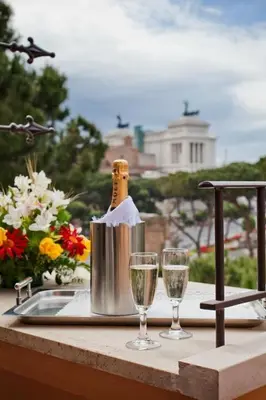 a bottle of champagne sitting on a table with two glasses at Hotel Romano in Rome