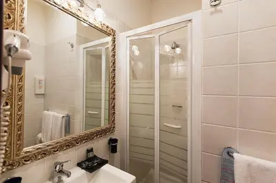 a bathroom with a mirror and a sink at Hotel Romano in Rome