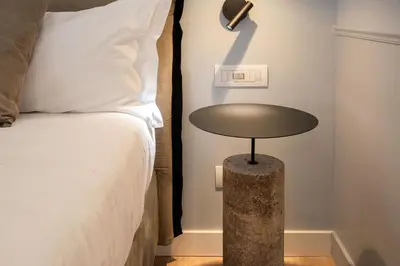 a table next to a bed in a room at Pantheon Suites Rome 2 in Rome