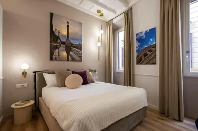 a bedroom with a large white bed with two windows at Pantheon Suites Rome 2 in Rome