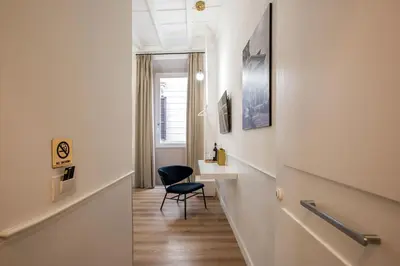 a hallway with a black chair and a desk at Pantheon Suites Rome 2 in Rome