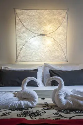 two swans sitting on top of a bed at Relais Fori Imperiali in Rome