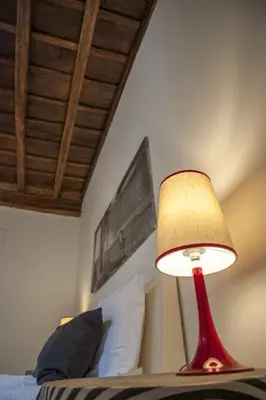 a red lamp sitting on top of a bed at Relais Fori Imperiali in Rome