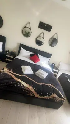 a bedroom with a black bed with many pillows at Vatican Sofia house in Rome