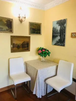 a table with two chairs and a vase of flowers at B&B Seneca in Rome