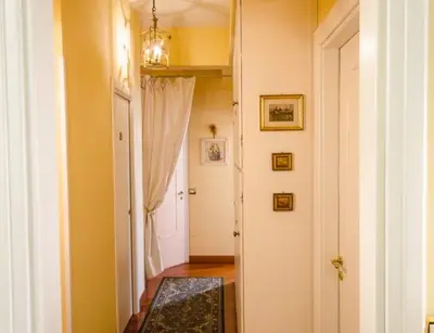 a hallway with a white door and a room with a rug at B&B Seneca in Rome