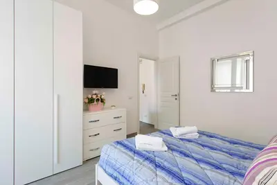a white bedroom with a bed and a tv at La Casa di Emanuela in Rome