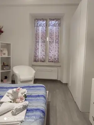 a small white room with a bed and a window at La Casa di Emanuela in Rome