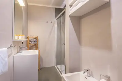 a white bathroom with a sink and a shower at Navona Stay in Rome