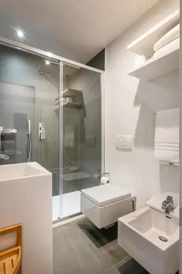 a white bathroom with a shower and a sink at Navona Stay in Rome