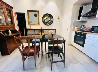 a kitchen with a table and chairs and a clock on the wall at Torre Tolomei Trastevere in Rome