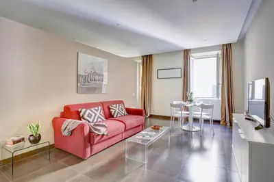 a living room with a red couch and a table at Colosseo Gardens - My Extra Home in Rome
