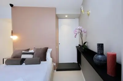 a bedroom with a white bed and a vase with flowers at YCH-Bright Penthouse near COLOSSEUM in Rome
