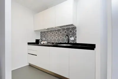 a kitchen with white cabinets and a sink at YCH-Bright Penthouse near COLOSSEUM in Rome