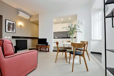 a living room with a pink couch and a table at YCH-Bright Penthouse near COLOSSEUM in Rome
