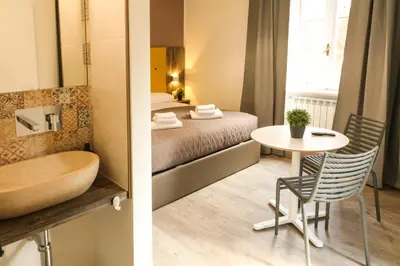 a bathroom and a bedroom with a tub and a table at BorgoNove in Rome