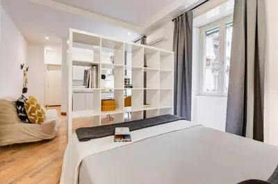 a white bedroom with a bed and a couch at Vasari's Home in Rome