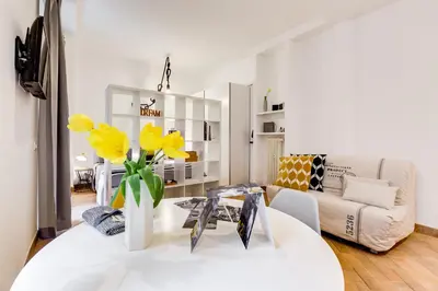 a living room with a white table and yellow flowers at Vasari's Home in Rome