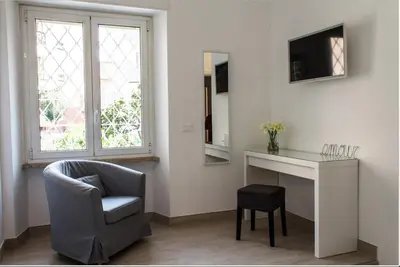 a living room with a chair and a desk and a television at Angolo sul Giardino in Rome