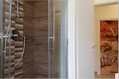 a shower with a glass door in a bathroom at Angolo sul Giardino in Rome