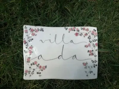 a sign with flowers on it on the grass at Angolo sul Giardino in Rome