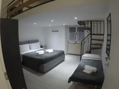 a bedroom with two beds and a spiral staircase at Your home near to the Vatican in Rome
