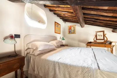 a bedroom with a white bed and wooden ceilings at Farnese Stunning Penthouse | Romeloft in Rome