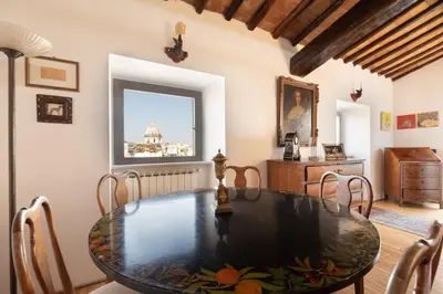 a dining room with a table and chairs and a window at Farnese Stunning Penthouse | Romeloft in Rome