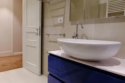 a bathroom with a white bowl sink on a blue cabinet at San Pietro Rhome in Rome