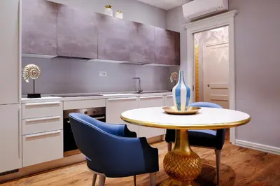 a kitchen with a table and blue chairs at San Pietro Rhome in Rome