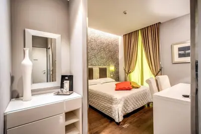 a small bedroom with a bed and a mirror at Boutique Rome Inn in Rome