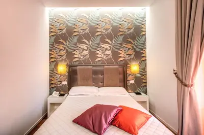 a bedroom with a bed with a floral wallpaper at Boutique Rome Inn in Rome
