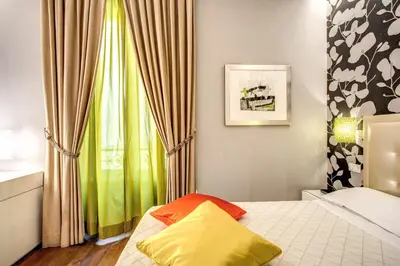 a bedroom with a bed and a window with curtains at Boutique Rome Inn in Rome