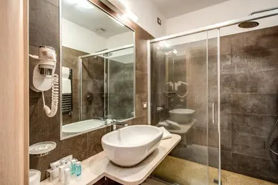 a bathroom with a sink and a glass shower at Boutique Rome Inn in Rome