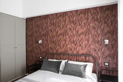 a bedroom with a bed and a red wall at Four Elements in Rome