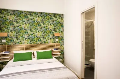 a bedroom with a bed with green pillows at Four Elements in Rome