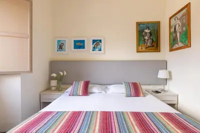 a bedroom with a large white bed with colorful pillows at Temple View FCollection Superior Relais in Rome