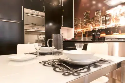 a kitchen with a table with white plates and silverware at LUXURY APARTMENT VATICANO-S'PETER BASILICA - NETFLIX Wifi - AirCond in Rome