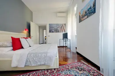 a bedroom with a white bed with red pillows at LUXURY APARTMENT VATICANO-S'PETER BASILICA - NETFLIX Wifi - AirCond in Rome