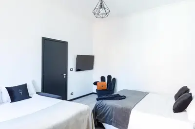 a bedroom with two beds and a black door at A World Aparts - 32 Modena in Rome