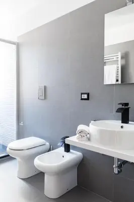 a white bathroom with a toilet and a sink at A World Aparts - 32 Modena in Rome