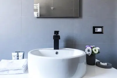 a white sink in a bathroom with a faucet at A World Aparts - 32 Modena in Rome