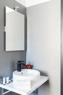 a bathroom with a white sink and a mirror at A World Aparts - 32 Modena in Rome