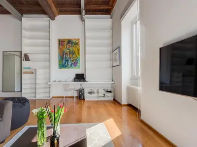 a living room with white walls and a large flat screen tv at Loft in Trastevere in Rome