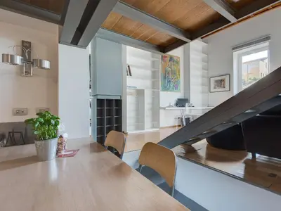 a dining room with a table and a staircase at Loft in Trastevere in Rome