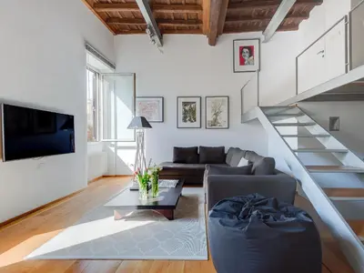 a living room with a couch and a staircase at Loft in Trastevere in Rome