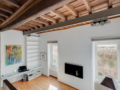 a living room with white walls and a flat screen tv at Loft in Trastevere in Rome