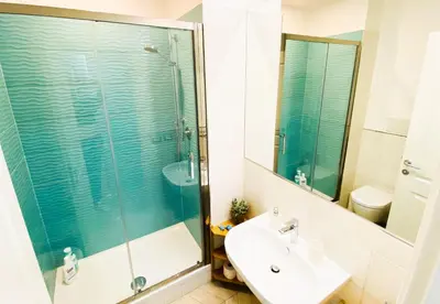 a bathroom with a glass shower and a sink at Trastevere Boulevard in Rome