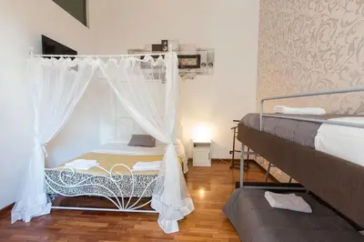 a bedroom with two beds and a canopy bed at Monia Coliseum Apartment in Rome